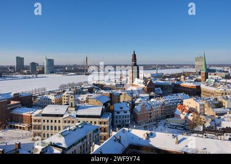 Panoramablick vom Turm der Peterskirche auf der Rigaer Kathedrale und den Dächern alter Häuser in der Altstadt von Riga, Lettland im Winter. Stockfoto