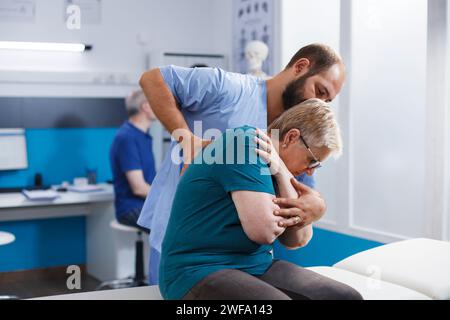 Osteopathischer Arzt, der Rücken- und Schulterknochen bei pensionierter alter Frau in chiropraktischer Sprechstunde knackt. Chiropraktiker als Hilfestellung für ältere Patienten bei der Genesung und Rehabilitation. Stockfoto