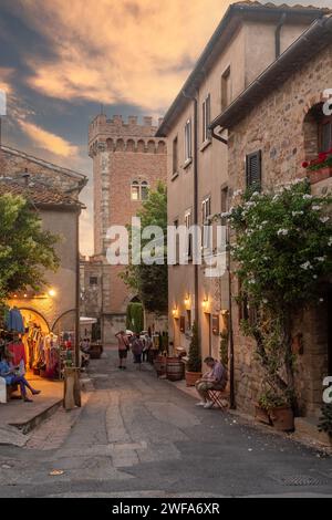 Gasse im mittelalterlichen Dorf auf den Hügeln der Maremma bei Sonnenuntergang im Sommer, Bolgheri, Livorno, Toskana, Italien Stockfoto