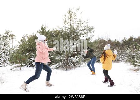 Glückliche Familie mit Schneeballschlacht im Freien am Wintertag. Weihnachtsferien Stockfoto