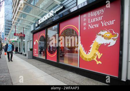 Vancouver, Kanada. Januar 2024. Ein Mann läuft am 29. Januar 2024 an einem chinesischen Mondneujahrsfenster vor einem Geschäft in der Innenstadt von Vancouver, British Columbia, Kanada vorbei. Einzelhandelsbetriebe schmücken ihre Räume mit thematischen Dekorationen, um das kommende chinesische Mondneujahr des Drachen vorzustellen. Quelle: Liang Sen/Xinhua/Alamy Live News Stockfoto