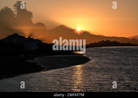 Doppelbelichtungsbild, aufgenommen während des Sonnenaufgangs vom White Rock Pier mit Blick entlang der Semiahmoo Bay in Richtung Mount Baker Stockfoto