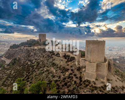 Blick aus der Vogelperspektive auf die mittelalterliche Burg Lorca mit Tour de Alfonz, quadratischen Türmen, die das gesamte lange Plateau des Hügels abdecken Stockfoto