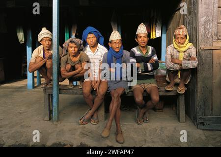 Eine Gruppe von Dorfmännern, die vielleicht auf die Arbeit als Träger im Dorf Hille im Osten Nepals warten Stockfoto