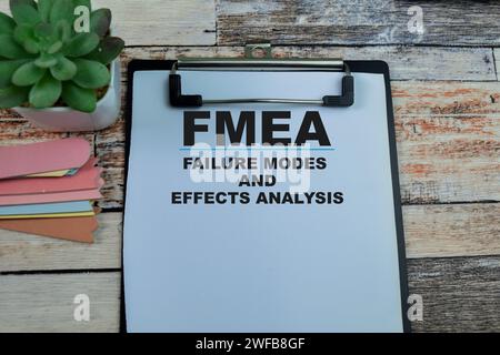 Konzept der FMEA - Fehlermodi und Wirkungsanalyse Schreiben Sie auf Unterlagen, die auf hölzernem Hintergrund isoliert sind. Stockfoto