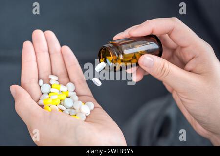 Mehrfarbige Pillen in einer Hand. Pflege der Gesundheit älterer Menschen. Einnahme von Medikamenten Stockfoto