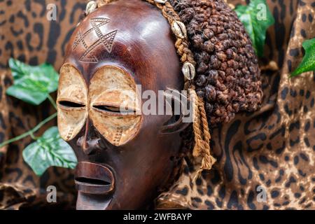 Afrikanische Holzmaske aus Uganda, zum Familien- oder Personenschutz, aus heimischem Holz, Seilen und Muscheln als Haarschmuck Stockfoto
