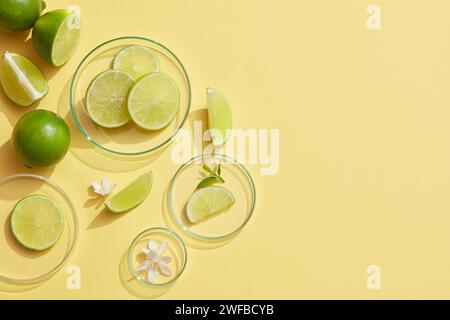 Einige Petrischalen aus Glas mit weißen Blüten und Limettenscheiben auf hellem Hintergrund. Leere Stelle auf der rechten Seite, um das Schönheitsprodukt von Lime ( Stockfoto