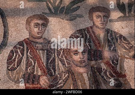 Jägertrio in Uniform. Detail aus dem spätrömischen Mosaik im Korridor der Großen Jagd, Villa Romana del Casale, Piazza Armerina, Sizilien, Italien. Die Mosaike im Korridor veranschaulichen die Jagd, das Fangen, das Einsetzen in Käfige und den Transport von Tieren, die für „Venationes“ oder Bestienbrillen bestimmt sind. Stockfoto