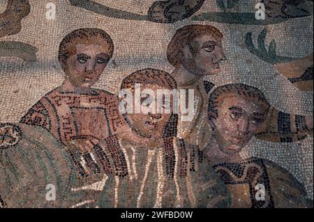 Jägergruppe in gestreiften und gemusterten Outfits. Detail aus dem spätrömischen Mosaik im Korridor der Großen Jagd, Villa Romana del Casale, Piazza Armerina, Sizilien, Italien. Die Mosaike im Korridor veranschaulichen die Jagd, das Fangen, das Einsetzen in Käfige und den Transport von Wildtieren, die für „Venationes“ oder Bestienbrillen bestimmt sind. Stockfoto