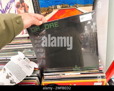 Berlin, Deutschland - 18. Januar 2024: Ein POV-Bild einer männlichen Hand, die in einem ikonischen Plattenladen im Musikgeschäft für eine Dr. Dre Musik-LP einkauft. Stockfoto