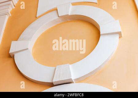 Klassische Architekturdetails, runder leerer weißer Rahmen auf gelber Steinmauer Stockfoto