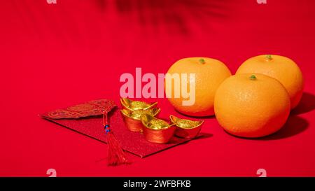 Chinesischer roter Hintergrund für das Mondneujahr. Alte chinesische Goldbarren, orange, roter Umschlag, Tae EIA, ang Pow, rotes Paket für Spendengeld zum chinesischen Neujahr Stockfoto