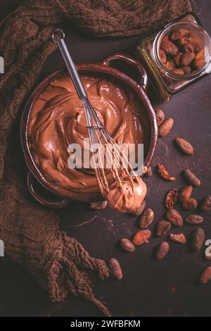 Schokoladen-Frischkäse-Mousse in einer Schüssel mit Schneebesen, gesunde hausgemachte zuckerfreie Snacks Stockfoto