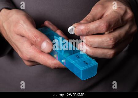 Der Mann nimmt Pillen aus der Kiste. Gesundheits- und Alterskonzept mit Medikamenten. Medikamente auf dem Tisch Stockfoto