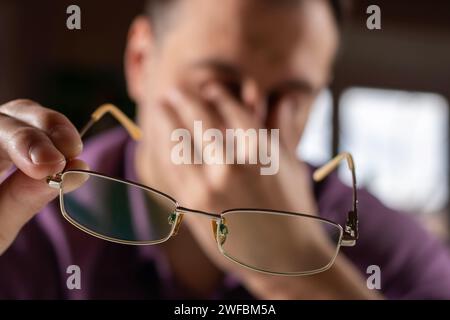 Müder junger Mann fühlt Schmerzen Augenanstrengung Brillen halten trockene Reizungen Augen müde von der Computerarbeit, gestresster Mann leiden unter Kopfschmerzen schlechte Vis Stockfoto