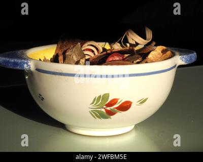 Ein Pot-pourri-Arrangement, dessen Inhalt aus getrockneten, natürlich duftenden Pflanzenmaterialien wie Samenkapseln und Blütenblättern in einer Faience de Quimper-Schüssel gewonnen wird. Stockfoto