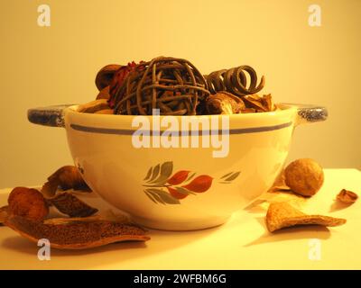 Ein Pot-pourri-Arrangement, dessen Inhalt aus getrockneten, natürlich duftenden Pflanzenmaterialien wie Samenkapseln und Blütenblättern in einer Faience de Quimper-Schüssel gewonnen wird. Stockfoto