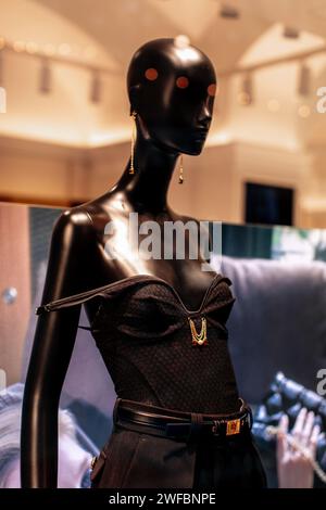 Stilvolle Schaufensterpuppe in einer schwarzen Hose mit Gürtel und kleiner Lederhandtasche Stockfoto