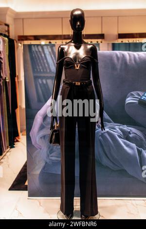 Stilvolle Schaufensterpuppe in einer schwarzen Hose mit Gürtel und kleiner Lederhandtasche Stockfoto