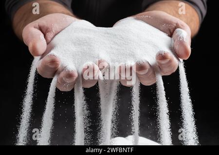 Sand, der durch die Hände läuft, als Symbol für das Laufen auf der Zeit. Stockfoto