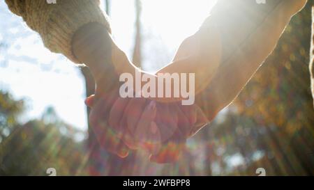 Nahaufnahme nicht wiedererkennbare multiethnische verheiratete Familie Paar in Liebe Hände halten Sonnenlicht liebevoll Mann Frau im Park im Freien romantisch Stockfoto