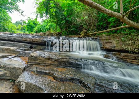 Wasserfall namens Tat Yai Wasserfall mit Gesteinsschicht und grünem Waldgrund in der lokalen Gegend namens Nam NAO District, Phetchabun, Thailand. Stockfoto