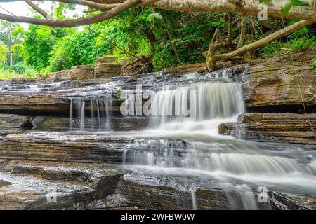 Wasserfall namens Tat Yai Wasserfall mit Gesteinsschicht und grünem Waldgrund in der lokalen Gegend namens Nam NAO District, Phetchabun, Thailand. Stockfoto