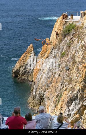 Acapulco, Mexiko - 17. Januar 2024: Touristen beobachten, wie die berühmten Klippentaucher in La Quebrada ins Meer tauchen Stockfoto