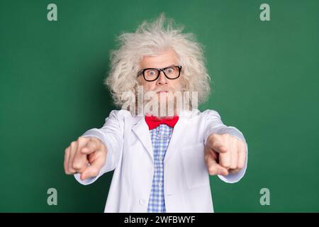 Foto eines ernsten verrückten, lustigen Wissenschaftlers in Brille mit unordentlichem Haarspitzfinger, den Sie auf grünem Hintergrund isoliert haben Stockfoto