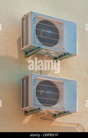 Zwei externe Klimaanlagen, die im Sommer an der Wand des Wohngebäudes montiert sind Stockfoto