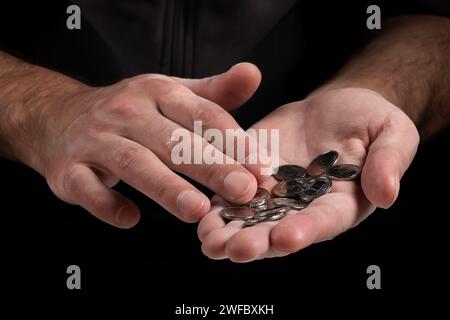 Man zählt Metallmünzen ukrainische Griwna. Armutsbegriff, Pensionszahlungen, Rentner mit Geld. Stockfoto