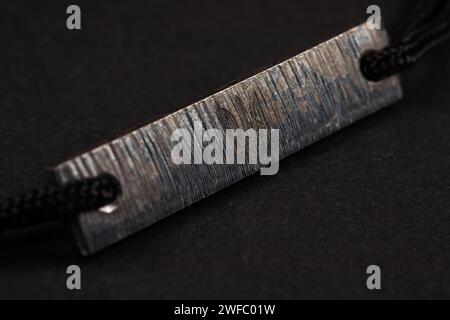 Azovstal Armband in limitierter Auflage aus Stahl von Azovstal auf dunklem Hintergrund. Emblem der Ukraine Stockfoto