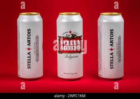 Ukraine. Dnipro. 20. märz 2023: Drei weiße Dose des großen belgischen Biers Stella Artois auf rotem Hintergrund. Alu-Dose Stella Artois Bier auf schwarzem B Stockfoto