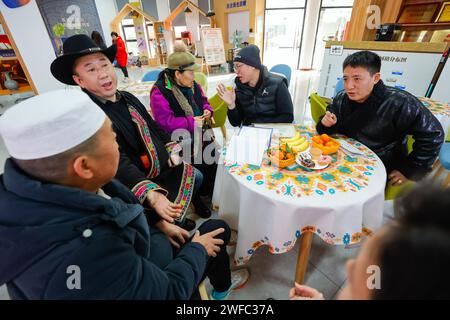 (240130) -- CHENGDU, 30. Januar 2024 (Xinhua) -- Nyima Wangden (1. R) diskutiert Fragen der Gemeindeverwaltung mit anderen Wirtschaftsvertretern in einem Gemeindedienstzentrum in Chengdu, südwestchinesische Provinz Sichuan, 16. Januar 2024. Nyima Wangden, ein tibetischer Geschäftsmann aus dem Tibetischen Heishui County und der Autonomen Präfektur Qiang in Sichuan, lebt seit über zwei Jahrzehnten in Chengdu, der Provinzhauptstadt. Nyima Wangden und seine Frau Hoing je, die beide das Handwerk der Gestaltung und Herstellung traditioneller tibetischer Kostüme von ihren Ältesten geerbt hatten, betreiben einen Sp Stockfoto