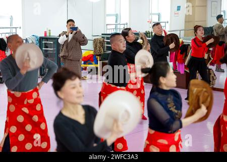 (240130) -- CHENGDU, 30. Januar 2024 (Xinhua) -- Nyima Wangden filmt Menschen, die in traditionellen tibetischen Kostümen tanzen, die von seinem Bekleidungsgeschäft in Chengdu, südwestchinesischer Provinz Sichuan, 20. Januar 2024 bereitgestellt werden. Nyima Wangden, ein tibetischer Geschäftsmann aus dem Tibetischen Heishui County und der Autonomen Präfektur Qiang in Sichuan, lebt seit über zwei Jahrzehnten in Chengdu, der Provinzhauptstadt. Nyima Wangden und seine Frau Hoing je, die beide das Handwerk der Gestaltung und Herstellung traditioneller tibetischer Kostüme von ihren Ältesten geerbt hatten, betreiben in Ji ein Spezialgeschäft für Bekleidung Stockfoto