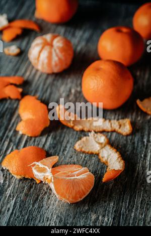 Nahaufnahme einiger geschälter Mandarinen auf einem grauen rustikalen Holztisch Stockfoto