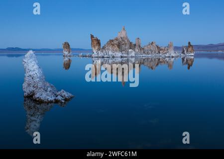 Tuffstein-Formationen spiegeln sich im Mono Lake in Kalifornien in der Abenddämmerung wider. Stockfoto