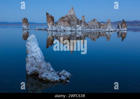 Tuffstein-Formationen spiegeln sich im Mono Lake in Kalifornien in der Abenddämmerung wider. Stockfoto