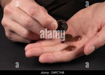 Der Mann hält Euro-Münzen in der Hand. Nahaufnahme Stockfoto