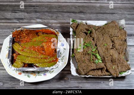 Arabische frittierte Rindleberscheiben, Rindleber bedeckt mit Weizenkleie (Kebda Bel Rada), was bedeutet, gebratene Kleie Leber, serviert mit Petersilie und Gurke Stockfoto