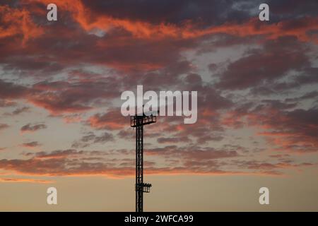 Flutlichter vor einer Wolkenbildung bei Sonnenuntergang Stockfoto