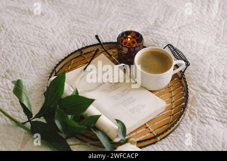 Offenes Buch mit Gläsern, Tasse Kaffee und Blumenstrauß mit weißen pinkfarbenen Pfingstrosen Stockfoto