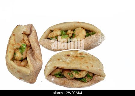 Gebratene Garnelen bedeckt mit Mehl und in tiefem heißem Öl frittiert, ein Sandwich gebratener Garnelen in einem traditionellen ägyptischen Fladenbrot mit Weizenkleie und Mehl Stockfoto