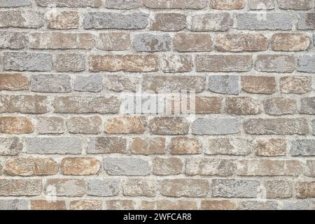 Muster des dekorativen Steinmauerhintergrunds. Moderne, beige Steinfliesen-Ziegelwand aus Nahaufnahme Stockfoto