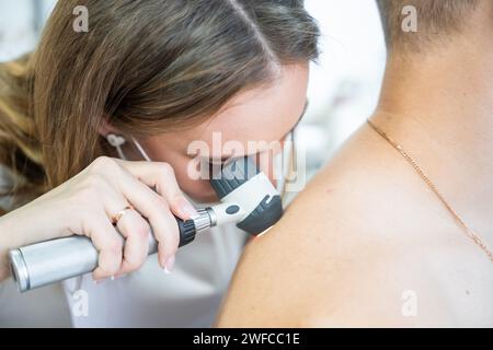 Der Arzt Dermatologe untersucht die Haut des Patienten. Dermatoskopie, Melanomprophylaxe, Hautkrebs. Stockfoto