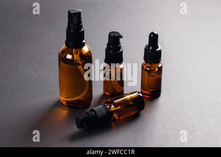 Braunglasflaschen für Kosmetik, Naturmedizin, ätherische Öle oder andere Flüssigkeiten auf dunklem Hintergrund Stockfoto