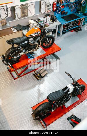 Draufsicht einer leeren Motorradwerkstatt mit kundenspezifischen Motorrädern über Plattformen, die zur Überprüfung bereit sind Stockfoto