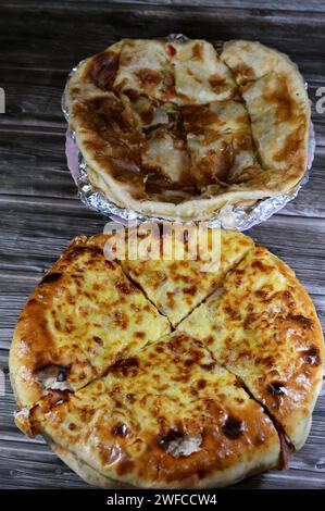 Hintergrund des mehrschichtigen gebackenen Pizzakuchens, besteht aus Schichten von Salami, Grillhähnchen, Käsemischung, Rindfleisch, Wurst, Mozzarella-Käse und Fleischsau Stockfoto