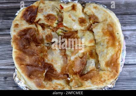 Im Ofen gebackener und in Stücke geschnittener Fleischkuchen aus dem Nahen Osten mit Fleischstücken, Hackfleisch, Tomaten, Paprika, Kräutern und Gewürzen Stockfoto